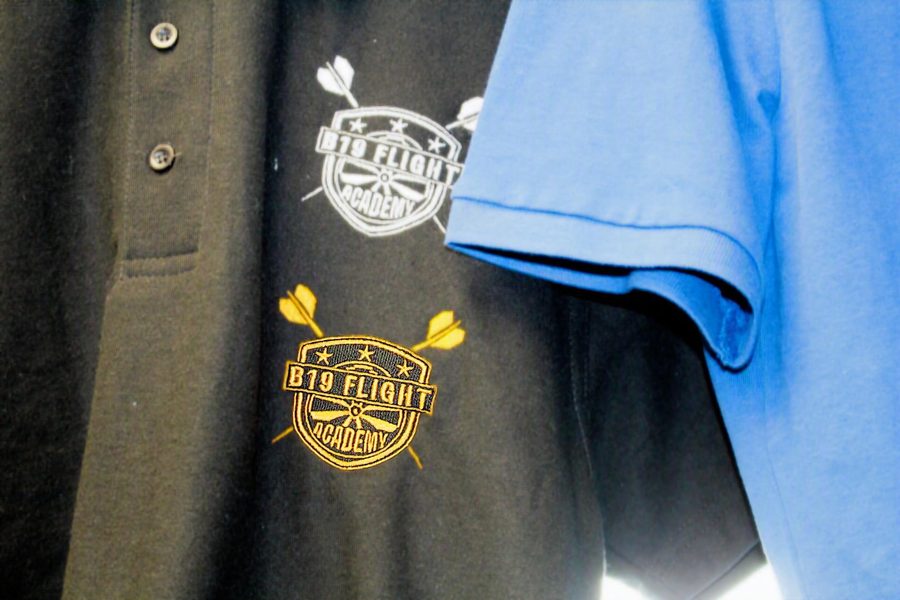 B19 Flight Academy logo embroidered in gold and white on black polo shirts by SVP Southend Embroidery