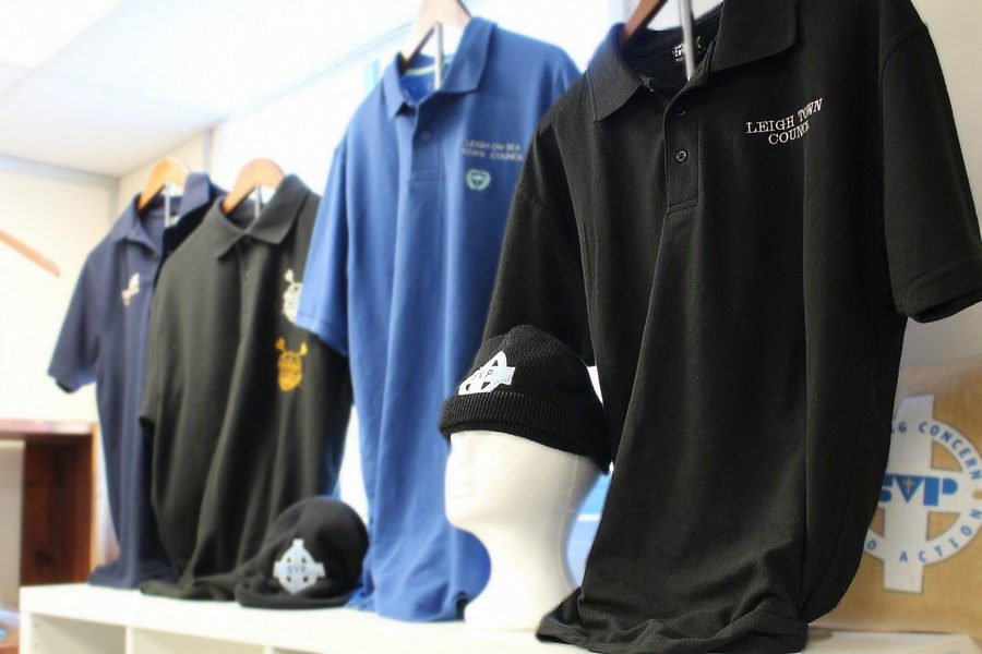 Collection of custom embroidered polo shirts and caps on display, including Leigh Town Council branded workwear by SVP Southend