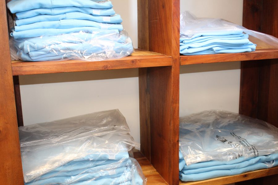 Shelves of packaged blue embroidered garments ready for dispatch at SVP Southend