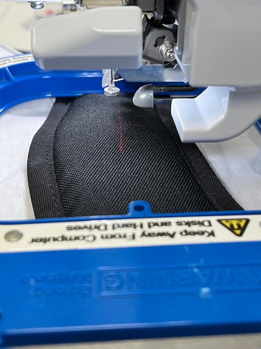 Personalised name embroidery being stitched onto a black school or gym backpack at SVP Southend