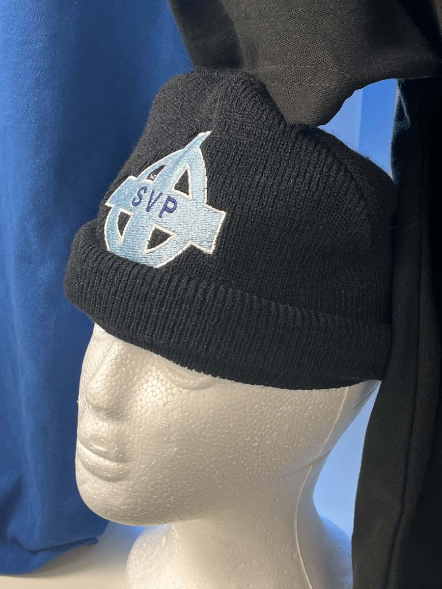 Black SVP beanie hat with embroidered cross logo displayed on a mannequin head