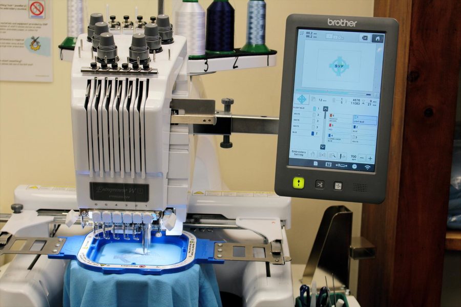 Brother Entrepreneur W15 embroidery machine stitching an SVP logo on blue fabric at SVP Southend